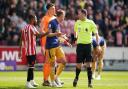 Newcastle's players argue with referee Chris Kavanagh about his decision to award Brentford a penalty