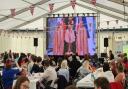 Crowds watch the Coronation on the big screen at Durham Rugby Club.