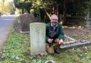 Historian Geoff Hill with the axe at the grave of George Edward Lumley
