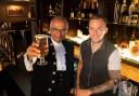 Dr Basu (left) raises a pint at The Court, with co-owner Terry Haley (right)