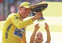 FRAUD: Lance Armstrong shows son Luke and twin daughters, Grace, right, and Isabelle, his seventh straight Tour de France cycling race trophy