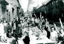 Children raise their arms in victory salutes before tucking into party food laid out in Brunswick Street, Darlington, to mark the end of the war