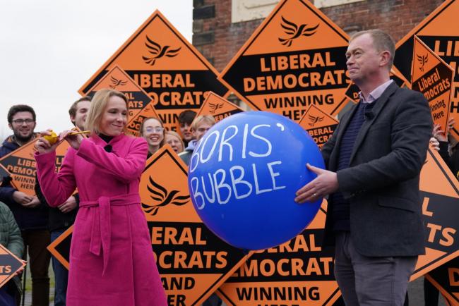 Newly elected Liberal Democrat MP Helen Morgan, bursts 'Boris' bubble' held by colleague Tim Farron, as she celebrates in Oswestry, Shropshire, following her victory in the North Shropshire by-electiom. Picture date: Friday December 17, 2021.
