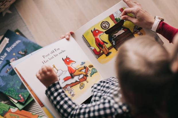 The Northern Echo: A child reading a picture book with their parent. Credit: Canva
