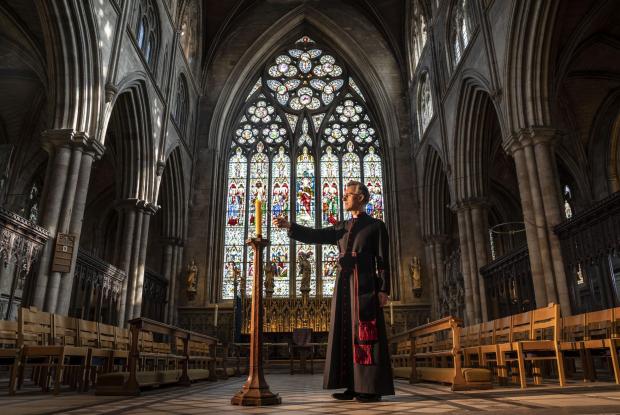 The Northern Echo: Very Reverend John Dobson Dean of Ripon lights a candle to mark the second anniversary of the first national coronavirus lockdown at Ripon Cathedral, North Yorkshire, ahead of the National Day of Reflection on Wednesday (PA)