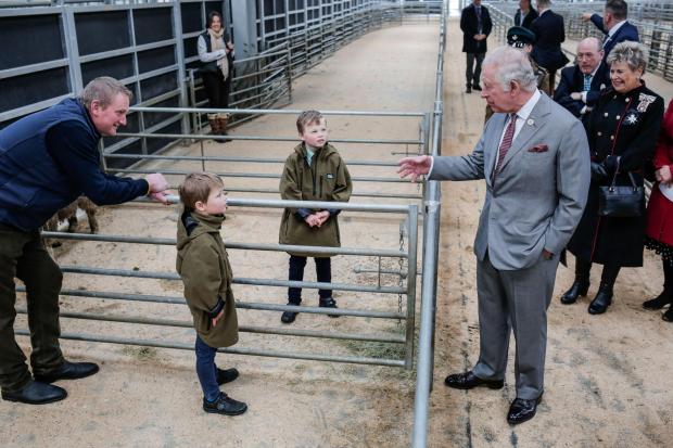The Northern Echo: The prince of Wales was greeted by mart worker and farmer Stephen Dodsworth and his two sons Freddie, eight, and Patrick, six. Picture: STUART BOULTON