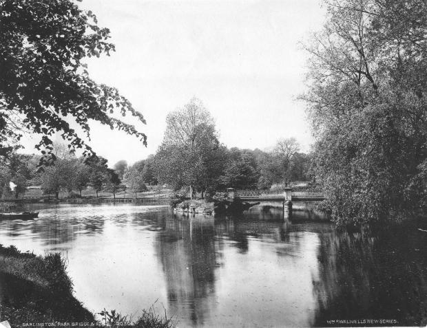 The Northern Echo: A footbridge in South Park. The Skerne used to fill this boating lake beneath the Park Lodge. We're looking south, towards the Parkside bridge, with Blackwell Grange in the distance out of sight behind the trees. The bridge took people from Penny