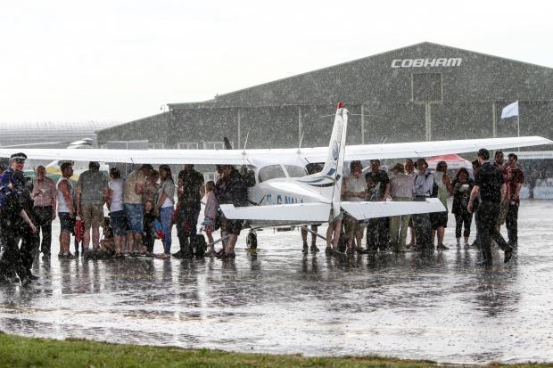 The Northern Echo: The sun doesn't always smile on the Teesside airshow as this picture of spectators huddling under the wings during a downpour shows