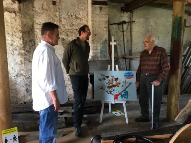 The Northern Echo: Cllr Stuart Parsons, Steve Green and volunteer Peter Burrage by the schematic diagram of the different water wheels and systems at Gayle Mill