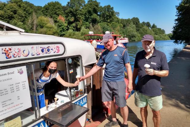 Alice Dungey, of the Two Hoots ice cream boat, serves ice cream to anglers Ian Goodall and Frank Woolford near York's Millennium Bridge  Picture: Mike Laycock