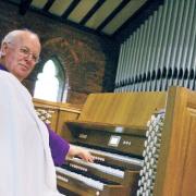 OLD AND NEW: George Barber at the digital keyboard, with the pipe organ behind