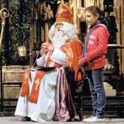 LITTLE HELPER: St Nicholas assisted by Emily Williamson from the Chorister School