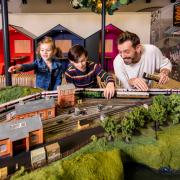 Broadcaster and railway historian Tim Dunn adds the finishing touches to a Hornby model train set featuring Flying Scotsman and an LNER Azuma train, with Holly, age 5, and Miles Trainor-McFerran, age 10 Picture: LNER