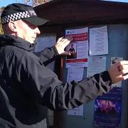 Police officer putting posters up in Danby as part of renewed murder investigation into death of Vicky Glass.
