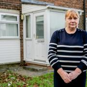 Christine Allan, who was hit with a £400 rent bill by a landlord for a flat (behind) she never moved into,