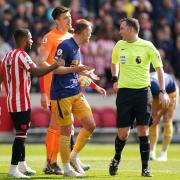 Newcastle's players argue with referee Chris Kavanagh about his decision to award Brentford a penalty