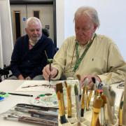 Ken Longstaff watches Malcolm Singleton as he sketches in pen and ink