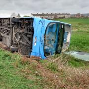 Two people have been hospitalised after the double-decker bus they were riding on toppled over on a rural road.