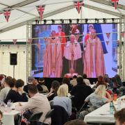 Crowds watch the Coronation on the big screen at Durham Rugby Club.