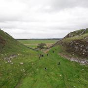 People gather at the site of the felled tree at Sycamore Gap.