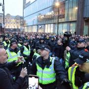 Police surround Newcastle and Dortmund supporters before Champion's League match.