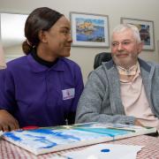 Ken Longstaff being helped with his painting by Miriam Balogun from Care Matters