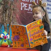 Reception’s Darcee-Mai Laidler shares a book with her new Reading Parrot