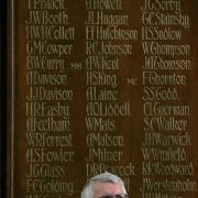 HERO REMEMBERED: Capt HR Wilson appears on the memorial board at the Queen Elizabeth Sixth Form College over historian Dennis Perkins’ left shoulder
