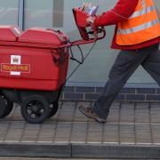 A Royal Mail worker delivering post