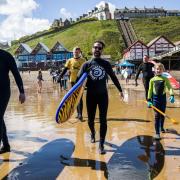 Surfers entering the water at Saltburn Beach.