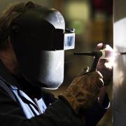 WHAT THEY DO: A Darchem Engineering worker welds a part for an aircraft carrier