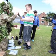 EARLY CHOICES: Left, Private Isaac Meehan, of the 104 Pioneer Sqadron, based in Coulby Newham, talks to pupils, from left, Callum Bousefield, Robert Harker, Alex Walton, all 11, and George McManners, ten, about military rations and rifles.