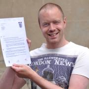 Referee Ollie O'Brien, with his certificate from the FA confirming his promotion to higher leagues