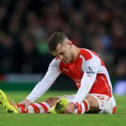 INJURY: Arsenal's Jack Wilshere sits injured on on the pitch. The midfielder will be out for approximately three months after undergoing successful surgery on his left ankle, Arsenal have announced