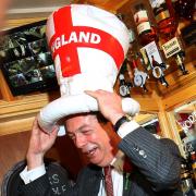 UKIP leader Nigel Farage celebrates St George's Day by trying on a suitable hat at a pub in Kent