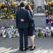 A couple look at floral tributes to the victims of the Westminster terrorist attack outside the Palace of Westminster, London. Picture:  Lauren Hurley/PA Wire