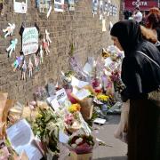 A woman leaves a floral tribute close to Finsbury Park Mosque in north London. Picture: John Stillwell/PA Wire
