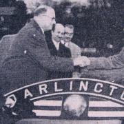 RAIL HANDOVER: Chairman of Darlington FC John Neasham, right, receives the nameplate from the scrapped steam engine in December 1960 from a British Rail official