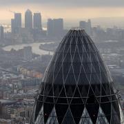 St Mary Axe also know as the 'Gherkin' and Canary Wharf at sunrise from the City of London. Picture: Stefan Rousseau/PA Wire