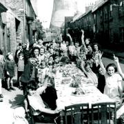 Children raise their arms in victory salutes before tucking into party food laid out in Brunswick Street, Darlington, to mark the end of the war