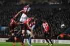HIGH-RISER: Aston Villa striker Christian Benteke leaps above John O'Shea and Carlos Cuellar to head home his side's third goal at Villa Park last night