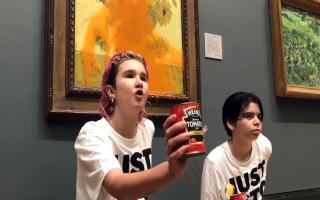 Two protesters who have thrown tinned soup at Vincent Van Gogh's famous 1888 work Sunflowers at the National Gallery in London. Picture: PA MEDIA