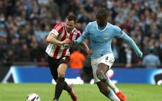 TOURE TUSSLE: Phil Bardsley tries to shrug off the attentions of Yaya Toure