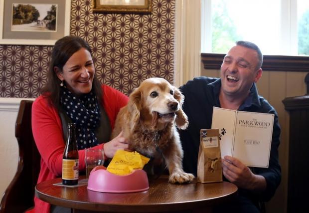 The Northern Echo: The Parkwood Hotel on Darlington Road in Stockton has introduced a menu for dogs. Bramble samples some of the sausages, accompanied by his owner and Northern Echo reporter Julia Breen and hotel landlord James Davies. Picture: CHRIS BOOTH