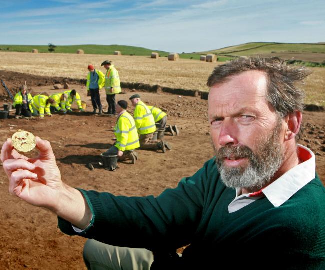 Archaeologist Steve Sherlock holds a gold Saxon bracteate, unearthed in fields on the coast, near Loftus.